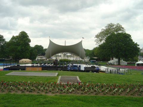 2001 Ford Crown Victoria - Outdoor stage and seating area prepared for an event, with the Washington Monument in the distance under a cloudy sky.