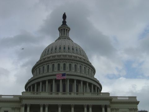 2001 Ford Crown Victoria - The dome of the US Capitol Building stands against a cloudy sky, with an American flag visible.