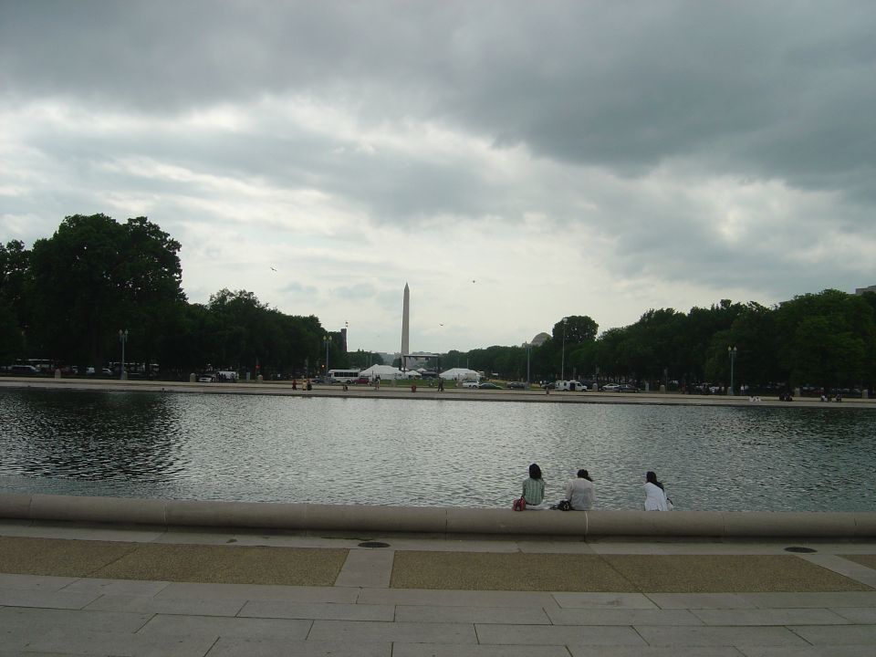 Washington Monument and Reflecting Pool with people sitting on the edge