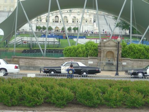 2001 Ford Crown Victoria - A vintage police car is parked next to a white sedan, with another police vehicle partially visible.