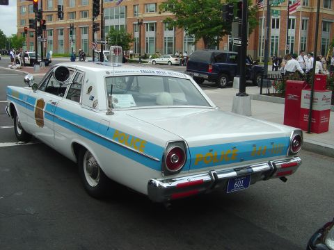 2001 Ford Crown Victoria - This vintage police car is marked with 'POLICE' and a blue stripe, seen from the rear.