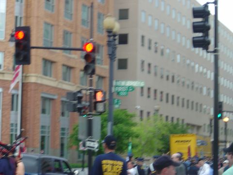 2001 Ford Crown Victoria - A police car is seen in traffic in front of a large building, with traffic lights and other vehicles visible.