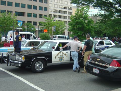 2001 Ford Crown Victoria - A police car with 'HIGHWAY PATROL' text is seen parked on a street with other vehicles.