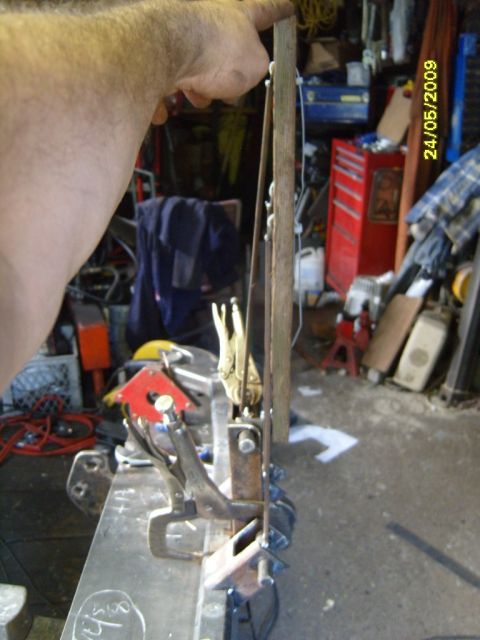 1989 Ford Bronco - A person is working on a metal fabrication project in a cluttered garage setting.