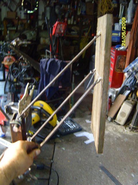 1989 Ford Bronco - A cluttered garage scene with a wooden post and various tools, including a yellow saw and a clamp.