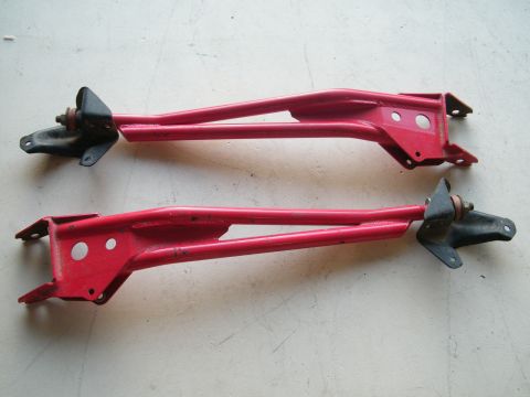 1982 Ford Bronco - Two red suspension control arms are displayed against a neutral background, likely for sale or identification.