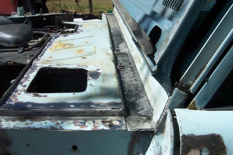 1976 Ford Bronco - Close-up of a damaged and prepped car body panel, revealing rust and repair work.