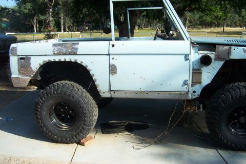 1976 Ford Bronco - Ford Bronco body in primer, with visible rust repair and bodywork in progress.