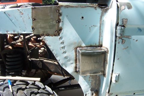 1976 Ford Bronco - This light blue Ford Bronco shows significant body damage and repair work on the fender and door area.