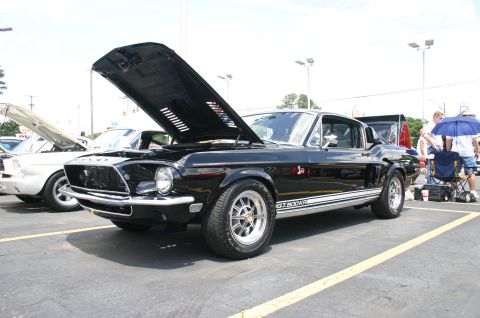 1968 Shelby GT500 - A black 1968 Shelby GT500KR is displayed with its hood open at a car show.