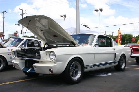 1968 Shelby GT500 - White 1965 Shelby GT350 at a car show, hood is open revealing the engine bay.