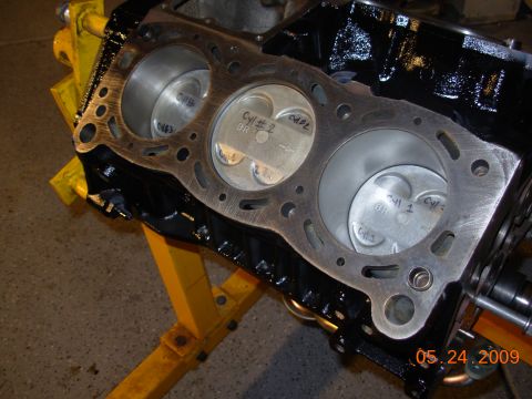 1995 Ford Taurus - Close-up of an engine block showing pistons inside the cylinders, with handwritten labels on the piston tops.