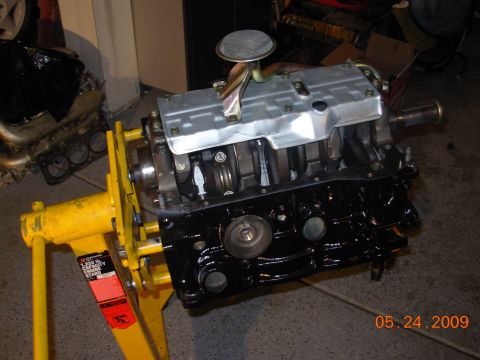 1995 Ford Taurus - Engine assembly mounted on a yellow stand, with visible crankshaft and oil pan details.