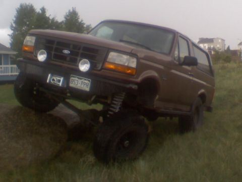 1993 Ford Bronco - This lifted 1993 Ford Bronco is shown off-road, with its front tire on a rock.