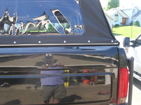 1996 Ford Bronco - Rear view of a black 1996 Ford Bronco with a soft top.