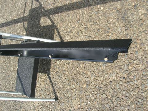 1996 Ford Bronco - A black trim piece with visible bolts is shown against a gravel background.