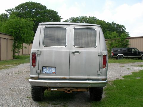 1978 Ford E250 - Rear view of a 1978 Ford E250 van parked outdoors, with another vehicle visible in the background.