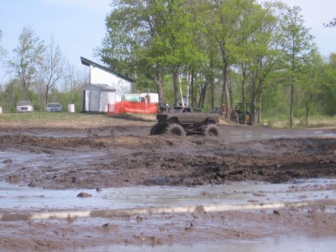1999 Chevrolet Avalanche - A heavily modified truck navigates a muddy track during an event.