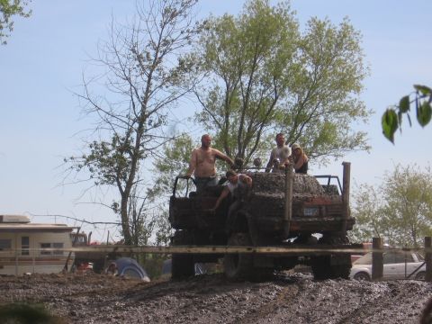 1999 Chevrolet Avalanche - People ride in a heavily mud-covered truck during an off-road event.