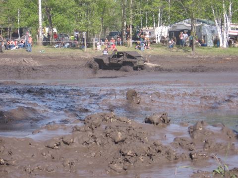 1999 Chevrolet Avalanche - A heavily modified truck navigates a challenging mud pit during an event.