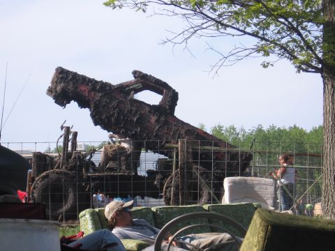 1999 Chevrolet Avalanche - A heavily mud-caked tractor sits behind a fence, its exhaust pipe pointing skyward.