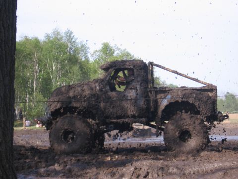 1999 Chevrolet Avalanche - This heavily modified truck is covered in mud as it navigates a challenging off-road course.