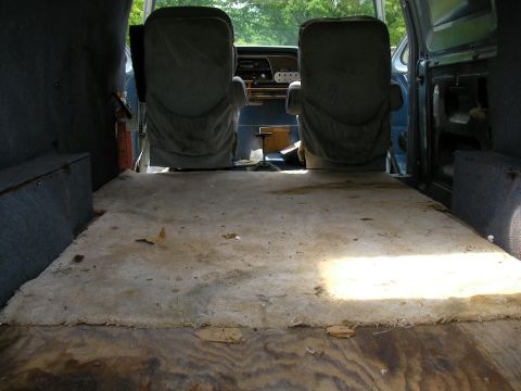 1978 Ford E250 - The interior of a van, viewed from the rear, shows the front seats and the floor of the cargo area.