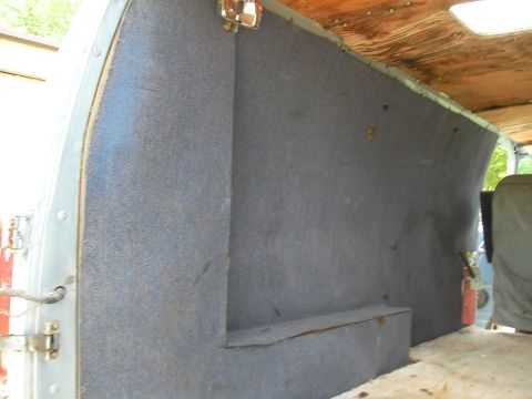 1978 Ford E250 - The interior of a van shows grey carpeted walls and a wooden ceiling with visible rivets.