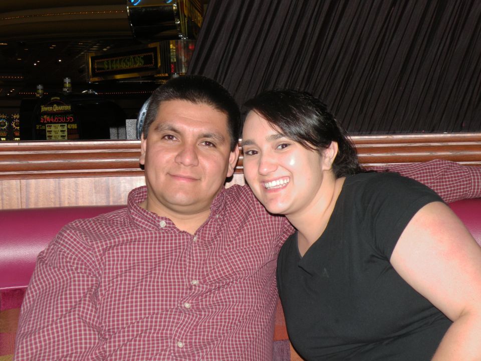 Couple sitting on a red couch in front of slot machines