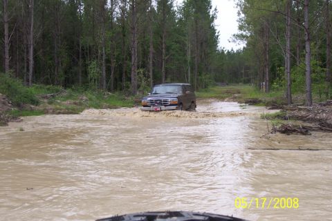 1967 Ford Mustang - Ford Bronco navigating a water obstacle on a wooded trail.