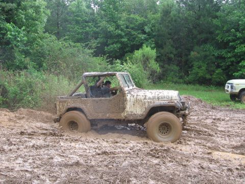 1967 Ford Mustang - A muddy Jeep navigates a difficult off-road trail, with another vehicle visible in the distance.