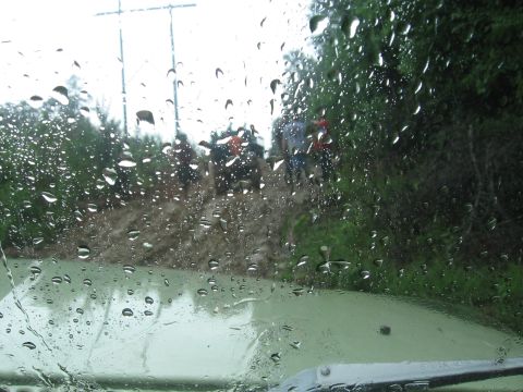 1967 Ford Mustang - Off-road vehicles driving through mud and water on a trail, seen through a wet windshield.