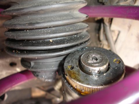1993 Ford Taurus - A close-up view of a vehicle's suspension strut boot and mount, showing signs of wear and tear.