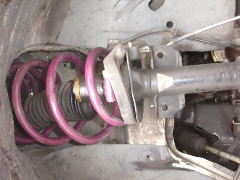1993 Ford Taurus - Front suspension strut assembly with a purple coil spring and protective boot.