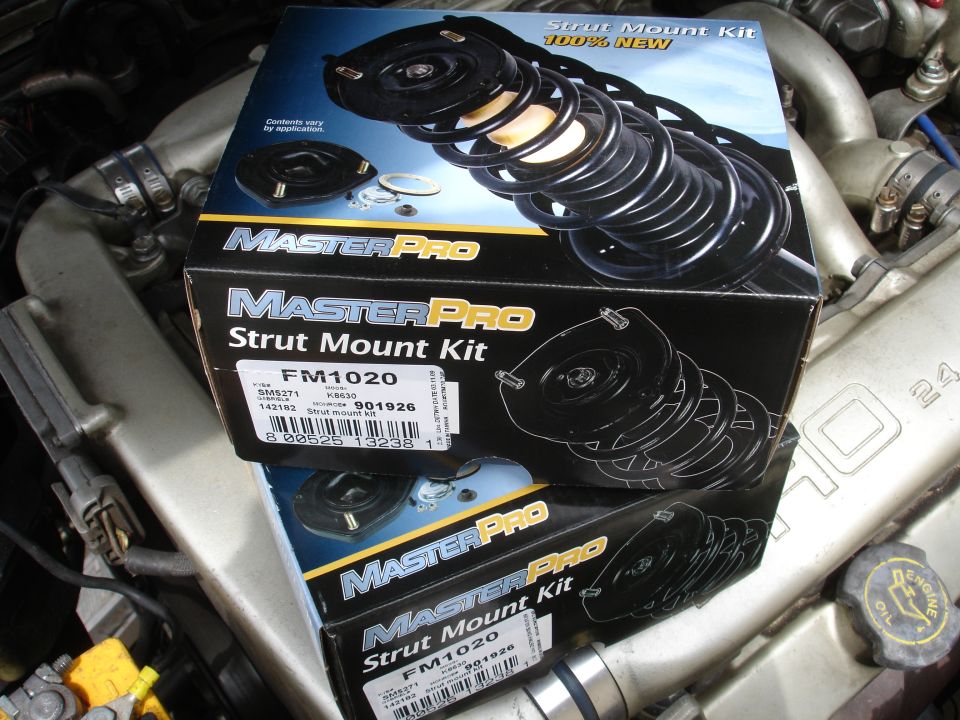 Two MasterPro Strut Mount Kit boxes stacked on top of engine components