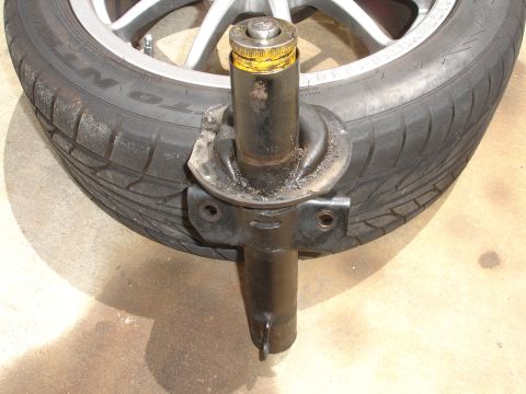 1993 Ford Taurus - A close-up view of a vehicle's strut assembly and tire, likely removed for service or replacement.