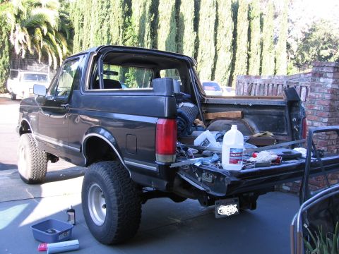 1989 Ford Bronco - This black 1989 Ford Bronco is viewed from the rear with its tailgate down, revealing a collection of tools and supplies.