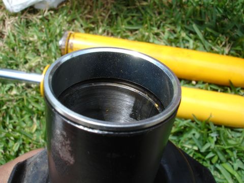 1993 Ford Taurus - A car strut assembly is shown with two yellow shock absorbers lying on the grass.