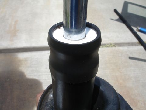 1993 Ford Taurus - A close-up view of a vehicle's shock absorber, highlighting its chrome shaft and protective rubber boot.