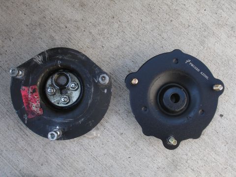1993 Ford Taurus - Pair of automotive strut mounts shown on a concrete surface.