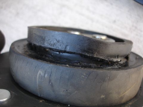 1993 Ford Taurus - A close-up view of a damaged rubber strut mount, showing signs of wear and tear.
