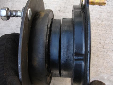 1993 Ford Taurus - A worn strut mount shows significant cracking in its rubber components, indicating potential failure.
