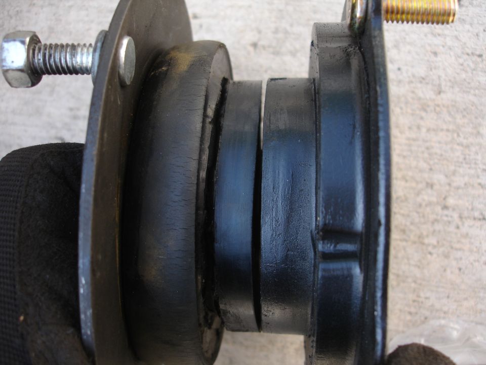Close-up of a worn strut mount with cracked rubber