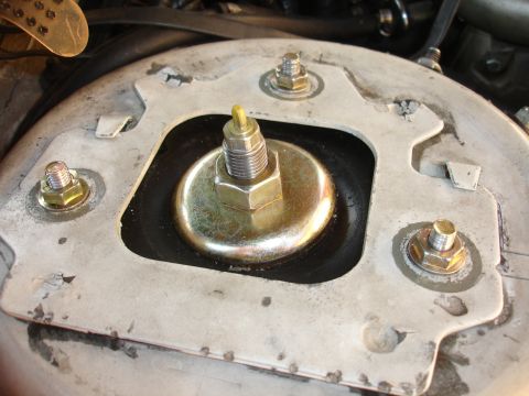 1993 Ford Taurus - This is a close-up view of a vehicle's strut mount assembly, showing the hardware that secures it.