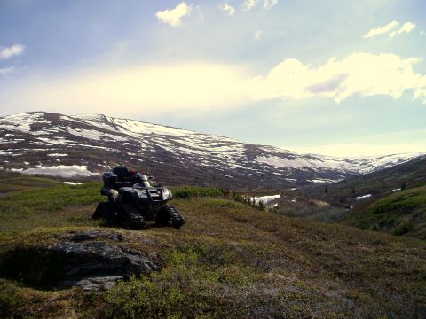 2000 Ford E350 - An ATV sits on a hill overlooking a valley with snow on the distant mountains.
