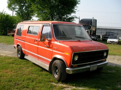 1978 Ford E150 - Orange Ford Econoline van parked outdoors with other vehicles visible in the background.