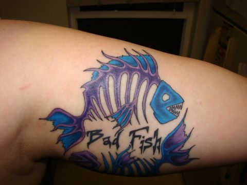 1989 Ford Bronco - Close-up of a tattoo on a person's upper arm depicting a blue and purple fish skeleton with the text "Bad Fish" in black lettering.
