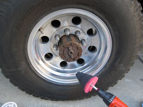 1986 Ford Bronco - A polishing tool is used on a vehicle's wheel, showing the tire and hub details.