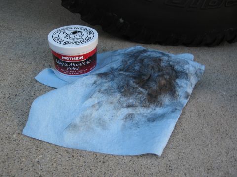 1986 Ford Bronco - A can of Mothers Mag & Aluminum Polish sits on a blue shop towel with a dirty rag and part of a tire visible.