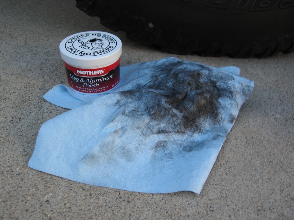 Mothers Mag & Aluminum Polish next to a dirty rag and tire